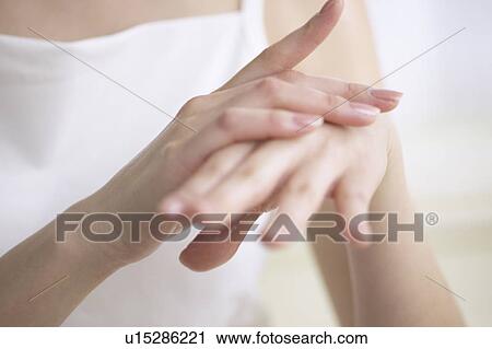 Stock Image - Young woman massaging hands, close up. Fotosearch