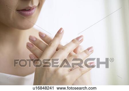 Stock Image - Young woman massaging hands, close up. Fotosearch