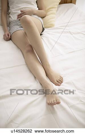 Stock Image - Young woman on bed. Fotosearch