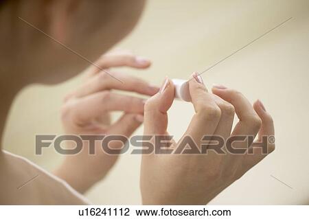 Stock Image - Young woman polishing nails, close up. Fotosearch