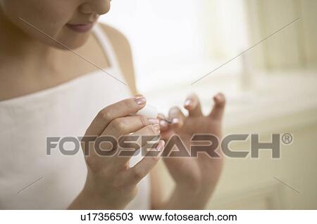 Young woman polishing nails, close up View Large Photo Image Stock Image - Young woman polishing nails, close up. Fotosearch