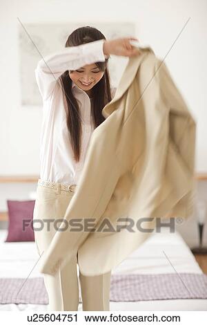 Young woman putting on jacket, blurred motion View Large Photo Image Stock Image - Young woman putting on jacket, blurred motion. Fotosearch