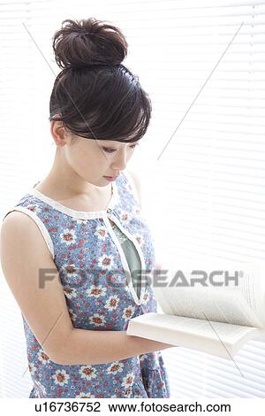 Young woman reading a book View Large Photo Image Stock Image - Young woman reading a book. Fotosearch