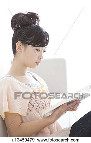 Young woman reading a book View Large Photo Image Stock Photo - Young woman reading a book. Fotosearch