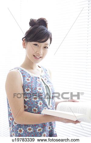 Young woman reading a book View Large Photo Image Stock Photo - Young woman reading a book. Fotosearch