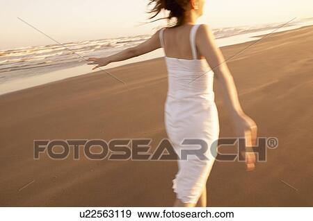 Young woman running on beach, blurred motion View Large Photo Image Stock Photo - Young woman running on beach, blurred motion. Fotosearch