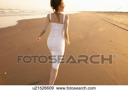 Stock Photo - Young woman running on beach. Fotosearch