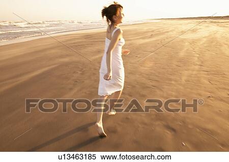 Stock Photography - Young woman running on beach. Fotosearch