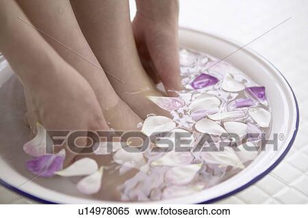 Young woman soaking feet and hands in bowl of water with flower petals, close up View Large Photo Image Stock Photography - Young woman soaking feet and hands in bowl of water with flower petals, close up. Fotosearch