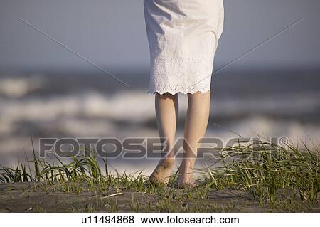 Stock Photo - Young woman standing on beach. Fotosearch