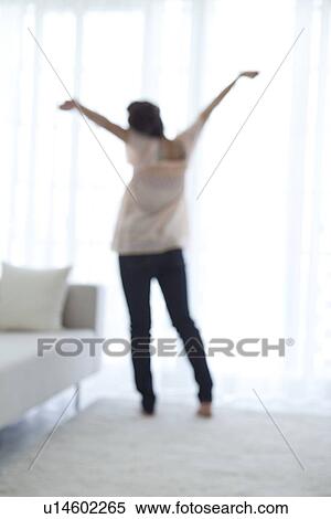 Young woman stretching by the window View Large Photo Image Stock Photography - Young woman stretching by the window. Fotosearch