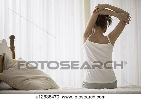 Young woman stretching on bed View Large Photo Image Stock Image - Young woman stretching on bed. Fotosearch