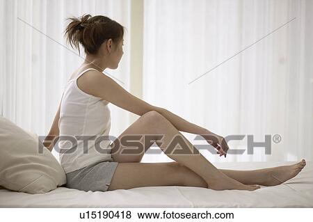 Young woman stretching on bed View Large Photo Image Stock Photo - Young woman stretching on bed. Fotosearch