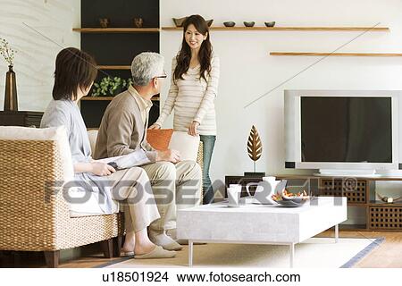 Young woman talking to her parents on sofa View Large Photo Image Picture - Young woman talking to her parents on sofa. Fotosearch