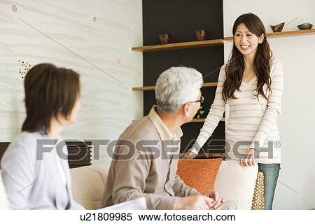 Young woman talking to her parents on sofa View Large Photo Image Stock Photography - Young woman talking to her parents on sofa. Fotosearch