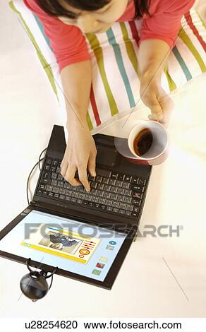Young woman using laptop View Large Photo Image Stock Image - Young woman using laptop. Fotosearch