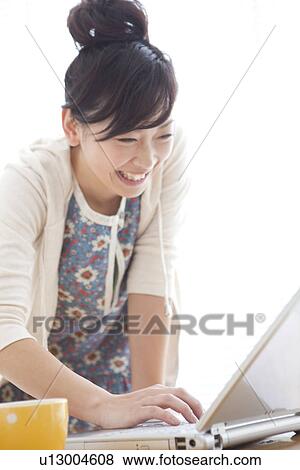 Young woman using laptop View Large Photo Image Stock Photo - Young woman using laptop. Fotosearch