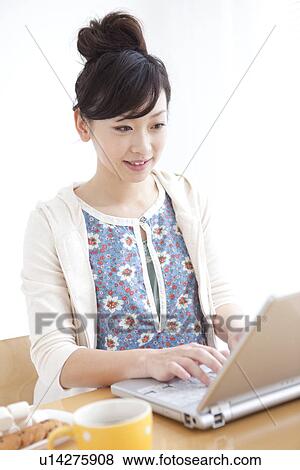 Stock Photo - Young woman using laptop. Fotosearch