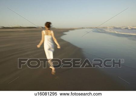 Young woman walking on beach, blurred motion View Large Photo Image Stock Photography - Young woman walking on beach, blurred motion. Fotosearch
