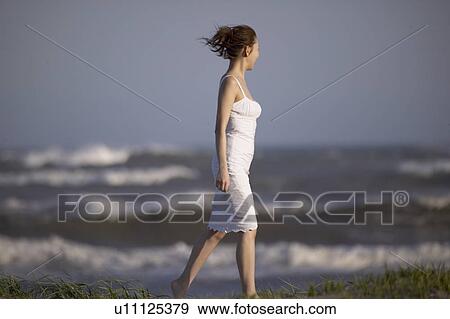 Young woman walking on beach View Large Photo Image Stock Photo - Young woman walking on beach. Fotosearch