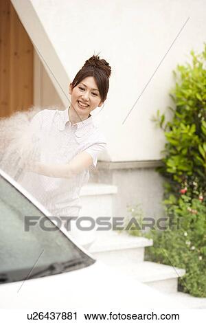 Young woman washing car, holding hose View Large Photo Image Stock Image - Young woman washing car, holding hose. Fotosearch