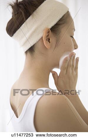 Stock Image - Young woman washing face. Fotosearch