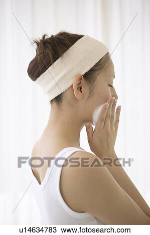 Stock Image - Young woman washing face. Fotosearch