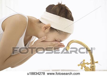 Stock Photo - Young woman washing face. Fotosearch