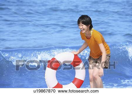Young woman with inner tube on beach, Toyama Prefecture, Honshu, Japan View Large Photo Image Stock Image - Young woman with inner tube on beach, Toyama Prefecture, Honshu, Japan. Fotosearch