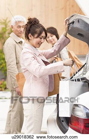 Young woman with parents picking shopping bag from boot View Large Photo Image Stock Image - Young woman with parents picking shopping bag from boot. Fotosearch