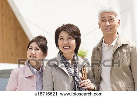 Young woman with parents standing by car, smiling and looking up View Large Photo Image Stock Image - Young woman with parents standing by car, smiling and looking up. Fotosearch