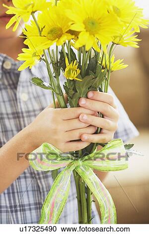 a boy holding a bouquet of yellow daisies View Large Photo Image Stock Image - a boy holding a bouquet of yellow daisies. Fotosearch