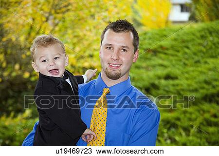 Stock Image - a father holding his young son. Fotosearch