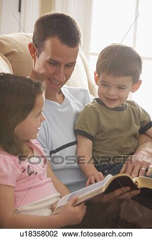 a father reading the bible to his young son and daughter View Large Photo Image Stock Image - a father reading the bible to his young son and daughter. Fotosearch