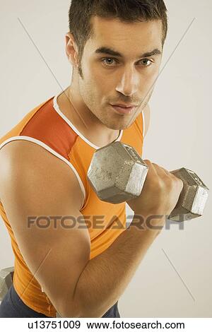 Stock Photo - a man lifting a free weight. Fotosearch