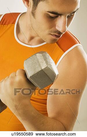 Stock Photo - a man lifting a free weight. Fotosearch