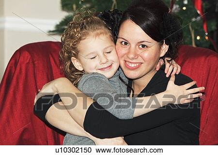 Stock Image - a mother hugging her daughter. Fotosearch