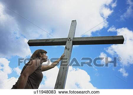 a woman holds on to the cross View Large Photo Image Stock Image - a woman holds on to the cross. Fotosearch