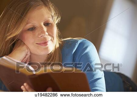 a young woman reading a book View Large Photo Image Stock Photograph - a young woman reading a book. Fotosearch