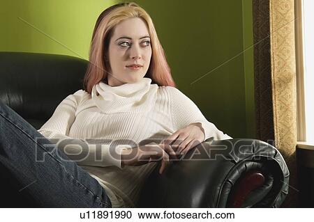 a young woman sitting in a chair View Large Photo Image Stock Image - a young woman sitting in a chair. Fotosearch