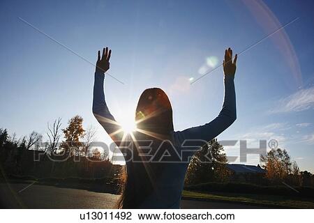 beams of sunlight and a circular glare around a teenage girl with her hands raised View Large Photo Image Stock Image - beams of sunlight and a circular glare around a teenage girl with her hands raised. Fotosearch