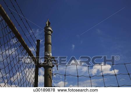 Stock Photo - camrose, alberta, canada; a chain link fence with barbed wire. Fotosearch
