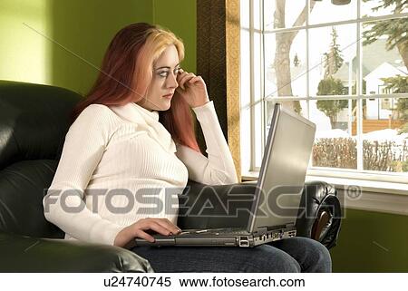 Stock Photography - edmonton, alberta, canada; a young woman working on her laptop computer. Fotosearch