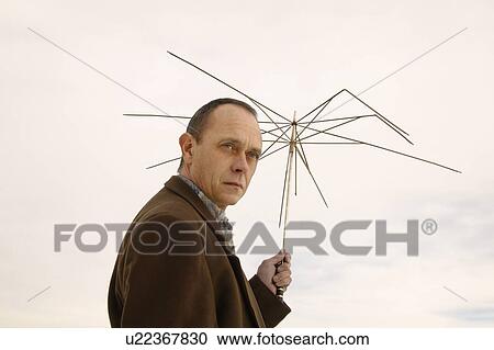 Man holding part of an umbrella View Large Photo Image Stock Image - Man holding part of an umbrella. Fotosearch