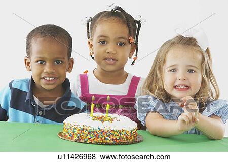 three children with a birthday cake View Large Photo Image Stock Photo - three children with a birthday cake. Fotosearch