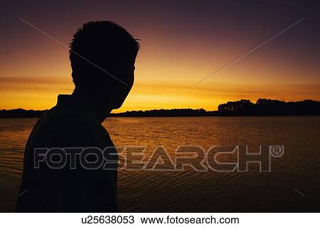 willmar, minnesota, united states of america; silhouette of a man watching the sunset over a lake View Large Photo Image Stock Image - willmar, minnesota, united states of america; silhouette of a man watching the sunset over a lake. Fotosearch