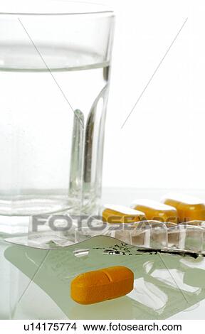 Picture - A glass of water and some pills. Fotosearch