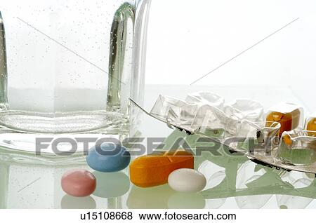 Stock Photo - A glass of water and some pills. Fotosearch