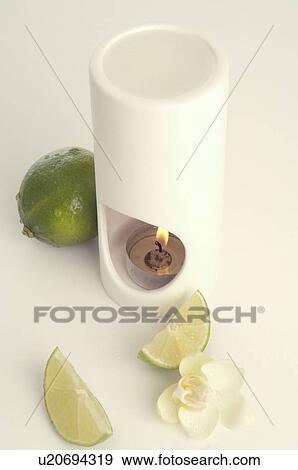 Stock Photo - Aroma lamp, limes and orchid blossoms. Fotosearch