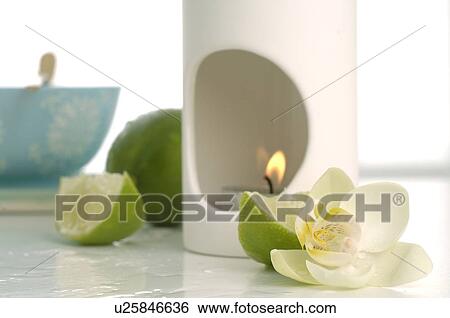 Stock Photograph - Aroma lamp, limes and orchid blossoms. Fotosearch